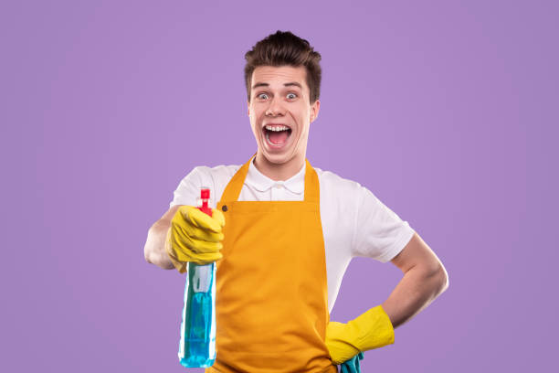 Happy man with detergent looking at camera stock photo