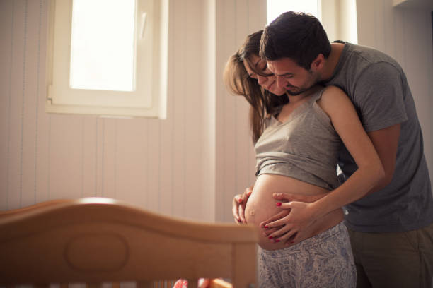 gelukkig man met zwangere vrouw - wiegman stockfoto's en -beelden
