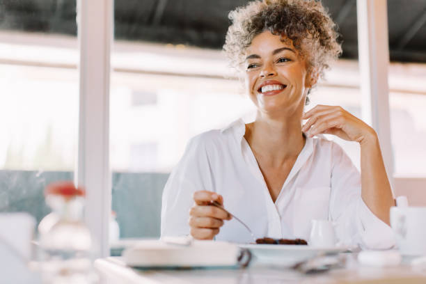 Happy mature woman looking away with a smile in a cafe stock photo