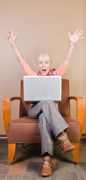 Happy mature woman with laptop stock photo