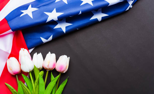 happy memorial day recuerde anteriormente, pero ahora rara vez llamado día de la decoración, bandera americana y una flor de tulipán sobre un fondo negro y espacio de copia, un día festivo federal en los estados unidos - memorial day fotografías e imágenes de stock