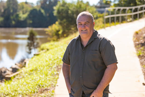 Happy Middle Aged Man Smiling by a River stock photo