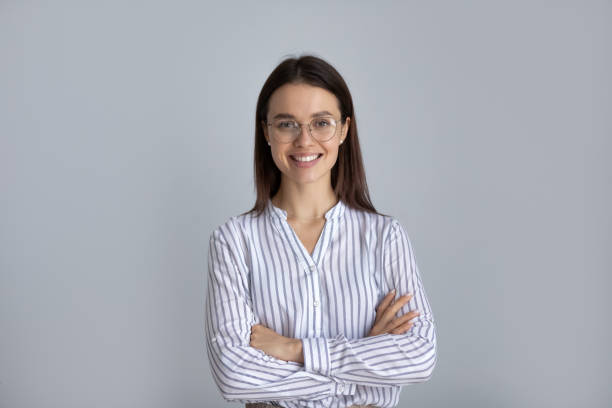 Happy millennial business woman in glasses posing with hands folded stock photo