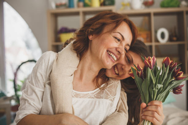 Happy mother and daughter with a bouquet of fresh tulips stock photo