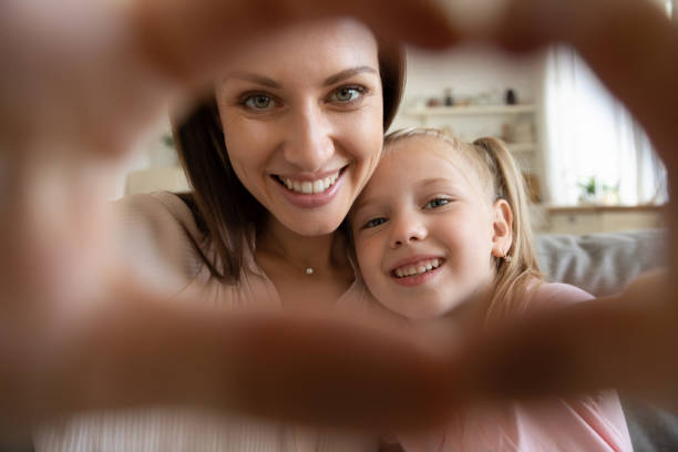 счастливая мать и маленькая дочь делают селфи, показывая знак сердца - hot selfie...