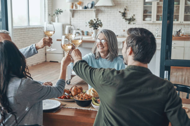 Happy multi-generation family toasting each other and smiling stock photo