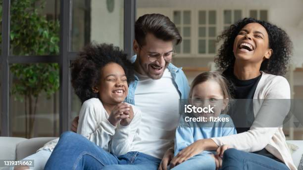 Happy multiracial family with little daughters relax at home