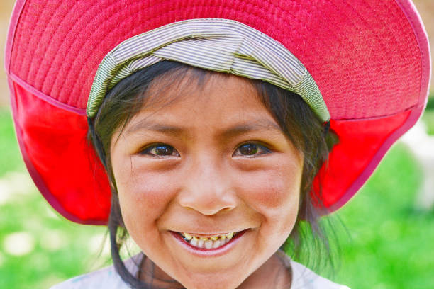 Happy native american girl. Little native american girl smiling and wearing bright pink hat. peru girl stock pictures, royalty-free photos & images