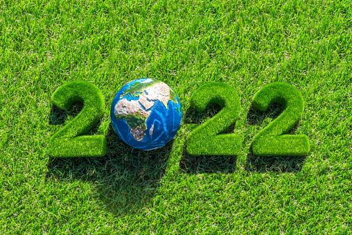 Happy New Year 2022 postcard, design with numbers and planet Earth covered in fresh green grass, ideal for greeting cards, holiday posters, and website headers.
Visual references from NASA (https://visibleearth.nasa.gov/images/74117/august-blue-marble-next-generation).
