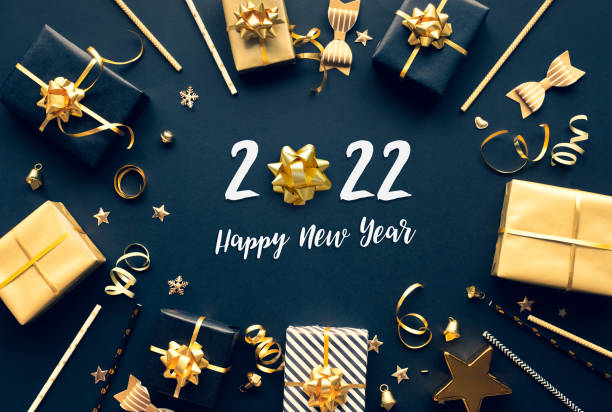 2022 happy new year celebration concepts with gift box and ornament in golden color on dark background. stock photo