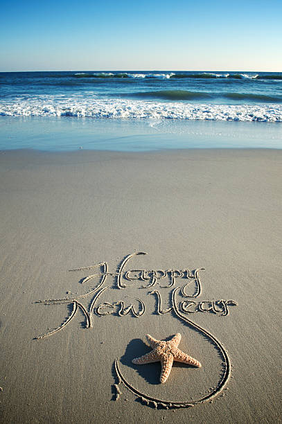 Happy New Year Message w Starfish on Smooth Beach stock photo