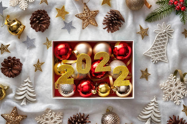 Happy New Year: Top view of Christmas box filled with golden and red balls on white and soft background stock photo