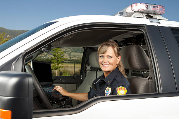 Happy Policewoman Driving Police Car on computer Happy Policewoman Driving Police Car on computer. This stock image has a horizontal composition. Arm Badge Create by me, Gold Chest Emblem Custom Ordered Generic border patrol stock pictures, royalty-free photos & images
