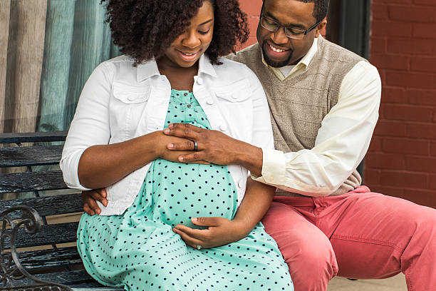 happy pregnant african american couple. - pregnant couple outside stockfoto's en -beelden