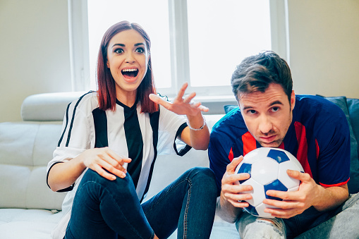 Happy Redhead Woman Wearing Soccer Jersey Watching A Game With Boyfriend - Fotografias de stock e mais imagens de Adulto - iStock