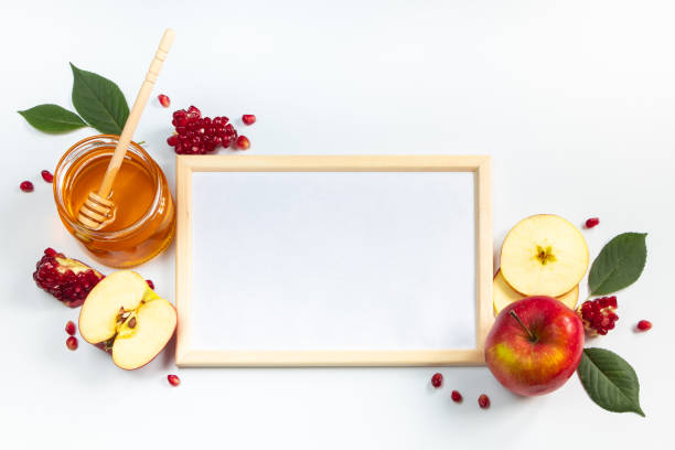 Happy Rosh Hashanah. Frame for congratulatory text. Apples, pomegranates and honey on white background. Traditional Judaism stock photo