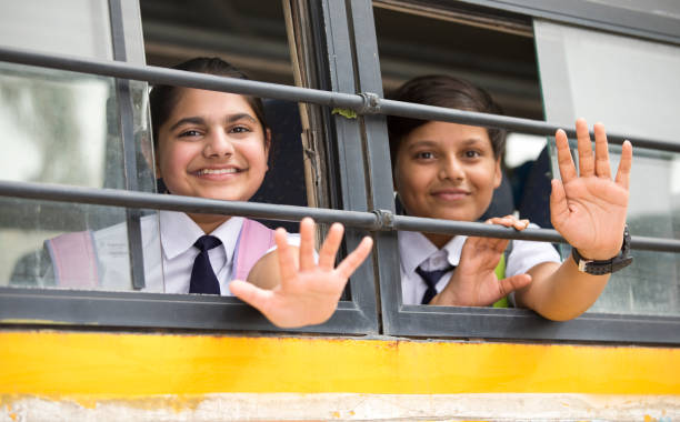 Happy school children waving hand from window of school bus Happy indian school children waving hand from window of school bus wave goodbye asian stock pictures, royalty-free photos & images