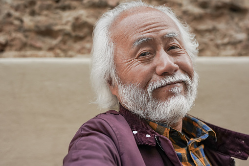Happy senior asian man smiling on camera - Elderly person taking a selfie