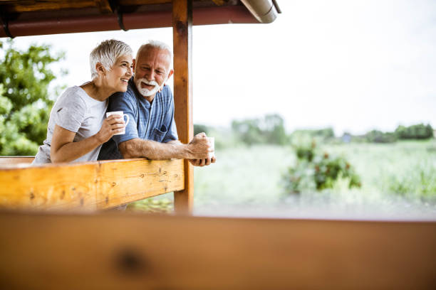 Happy senior couple enjoying in morning coffee on a terrace. Happy mature couple having their morning coffee on a balcony and looking at view. Copy space. sunday morning coffee stock pictures, royalty-free photos & images