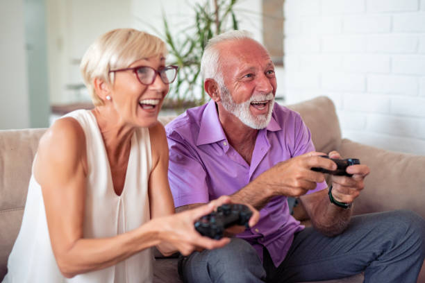 Happy senior couple playing video games stock photo