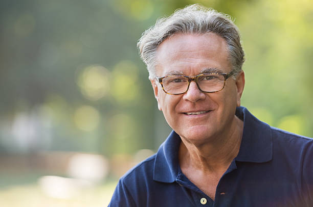 Happy senior man Portrait of senior man smiling and loooking at camera. Face of a happy old man wearing eyeglasses outdoor. Retired man with grey hair relaxing at park during morning. mature men stock pictures, royalty-free photos & images