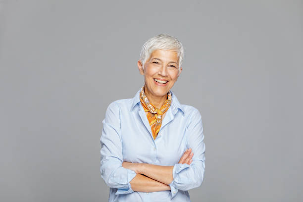 Happy senior woman against grey background. Portrait of beautiful mature business woman in casual clothes isolated over grey background. Attractive middle aged woman with beautiful smile. mature women beauty beautiful fashion model stock pictures, royalty-free photos & images