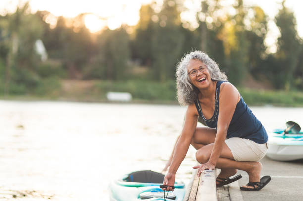 lycklig senior kvinna på en kajak resa - woman kayaking bildbanksfoton och bilder