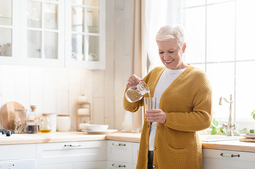 happy senior woman pouring water into glass in kitchen picture id1307929484?b=1&k=20&m=1307929484&s=170667a&w=0&h=KAgT5nygNn2fIpWdgLYrBOJ29wqImhT3V3YUyAKZQAU=