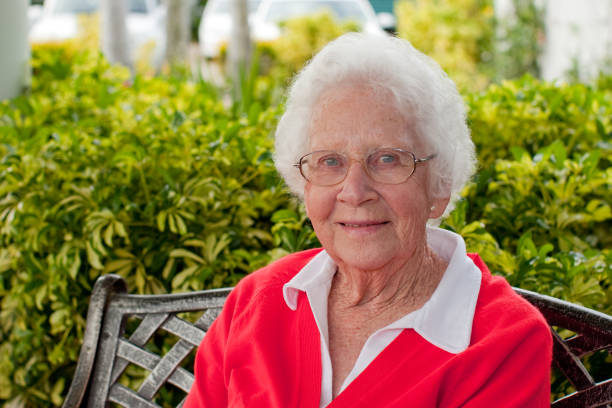 Happy Senior Woman sitting outdoors in the garden stock photo