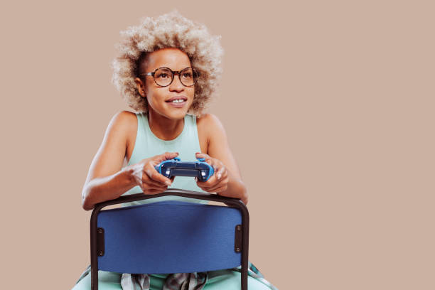 Happy smiling afro latin american woman playing video game with controller stock photo