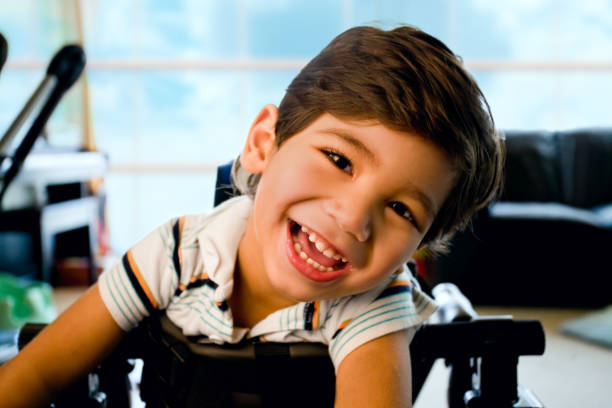 Happy smiling biracial disabled little boy standing in walker stock photo