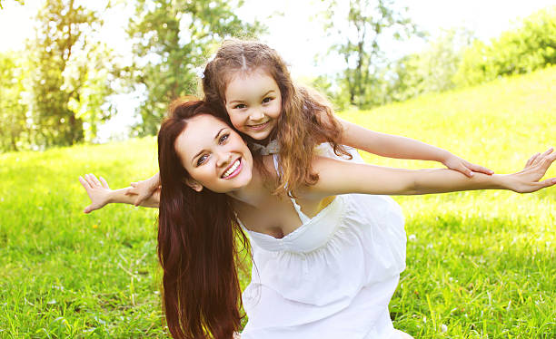 Happy smiling mother and daughter child having fun together outd Happy smiling mother and daughter child having fun together outdoors in sunny summer day mother and child stock pictures, royalty-free photos & images