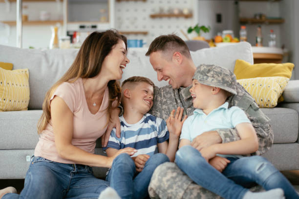 Happy soldier sitting on the couch with his family. Happy soldier sitting on the couch with his family. Soldier and his wife enjoying at home with children. infantry stock pictures, royalty-free photos & images