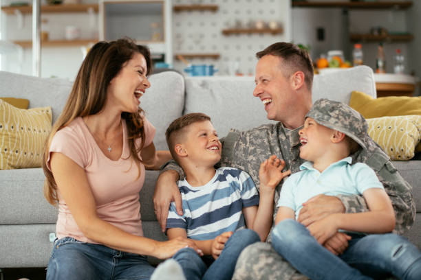 Happy soldier sitting on the floor with his family. stock photo