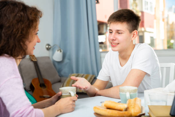Happy teenager talking to mom Portrait of happy teenager having friendly chat with his mom at home mother and teenage son stock pictures, royalty-free photos & images