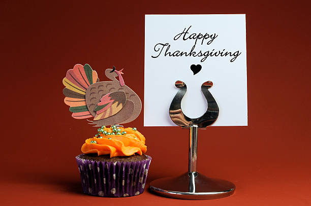Happy Thanksgiving message on table stand with orange cupcake Happy Thanksgiving message on table stand with orange chocolate cupcake with turkey decoration. turkey cupcakes stock pictures, royalty-free photos & images