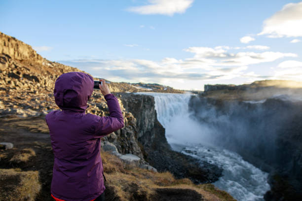 Happy tourist against Dettifoss waterfall background Happy tourist against Dettifoss waterfall background iceland dettifoss stock pictures, royalty-free photos & images