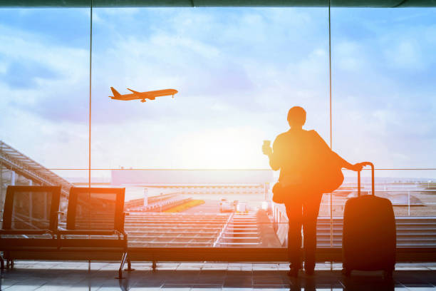 happy traveler waiting for the flight in airport happy traveler waiting for the flight in airport, departure terminal, immigration concept commercial airplane stock pictures, royalty-free photos & images