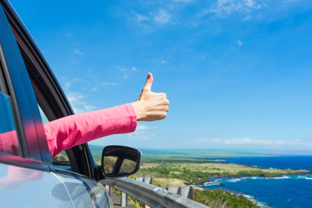 Happy traveler with thumb up Female traveler on the road holding thumbs up. car insurance stock pictures, royalty-free photos & images
