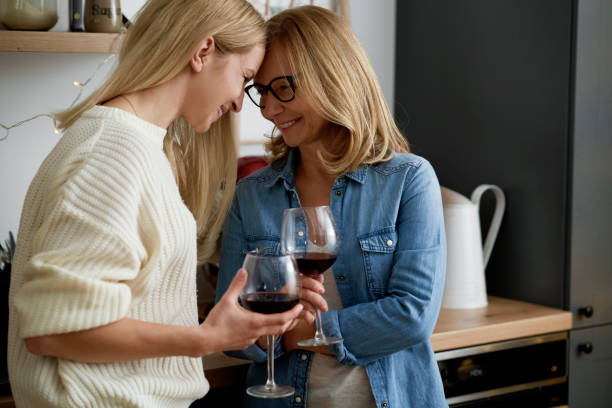 Happy two women standing with glasses of wine stock photo