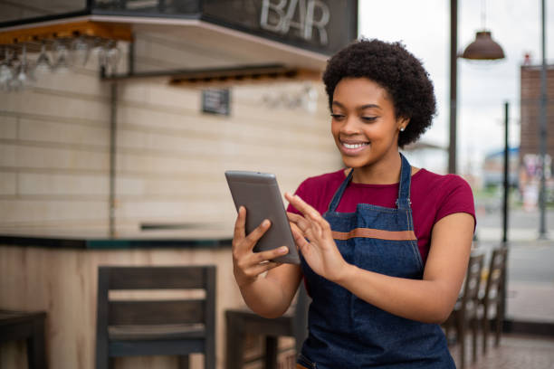 Happy waitress at a restaurant writing an order on a tablet computer Happy African American waitress at a restaurant writing an order on a tablet computer and smiling - food service concepts waiter taking order stock pictures, royalty-free photos & images