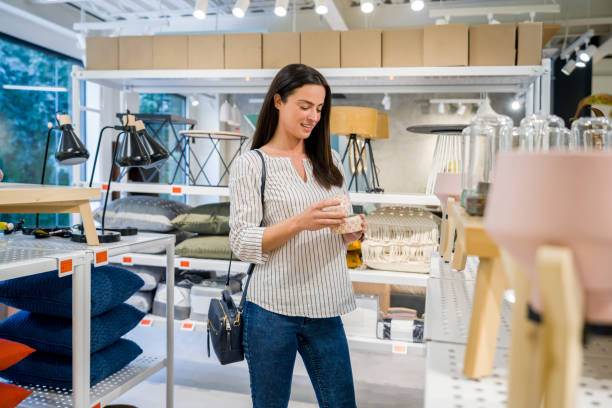 Happy woman buying home decor at a furniture store Happy Latin American woman buying home decor at a furniture store and smiling - lifestyle concepts buying stock pictures, royalty-free photos & images