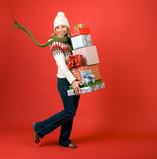 Happy Woman Carrying Many Christmas Gifts stock photo