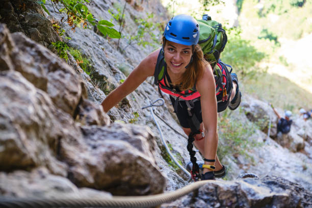 Happy woman climbing a via ferrata route in Turda Gorge (Cheile Turzii), Romania. stock photo