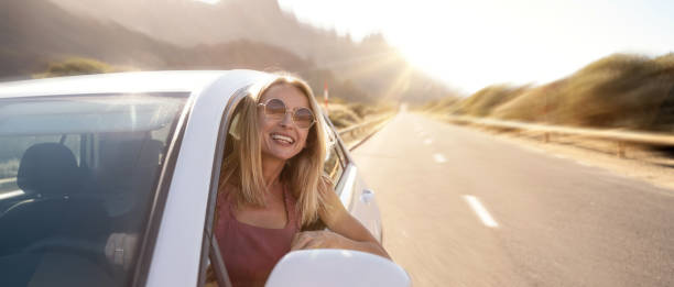 happy woman driving a car and smiling, traveling on the sunny summer day. - cargo canarias imagens e fotografias de stock