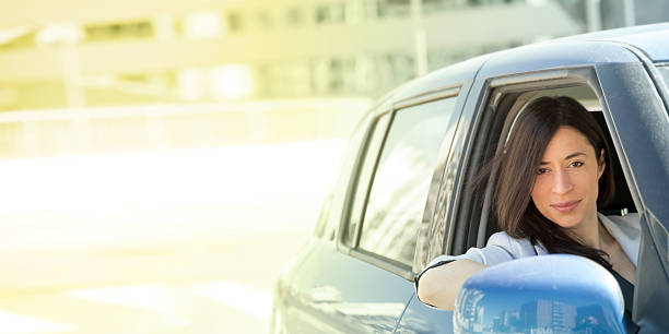 Happy woman driving her car stock photo