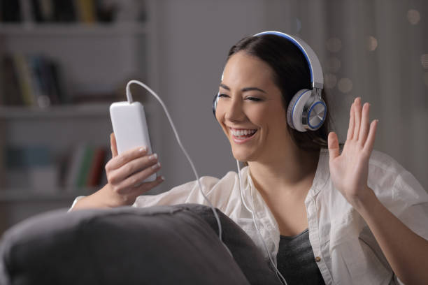 Happy woman having a video call in the night on couch Happy woman having a video call in the night on couch free video chat with women stock pictures, royalty-free photos & images