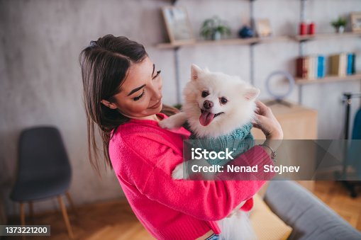 istock A happy woman holds her dog Spitz in her arms 1373221200