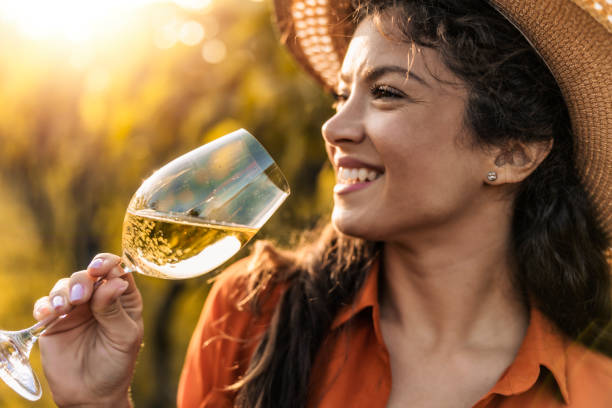 Happy woman in the vineyard,drink wine stock photo