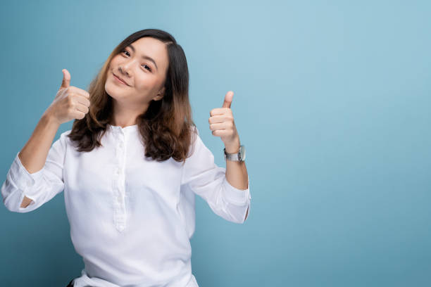 Happy woman showing thumb up isolated on background stock photo